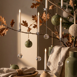 Flameless LED candles with hanging crystal look ornaments on decorative branches, close-up