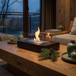 Glass and metal tabletop ethanol fire bowl close-up, on an oak coffee table with a calm flame