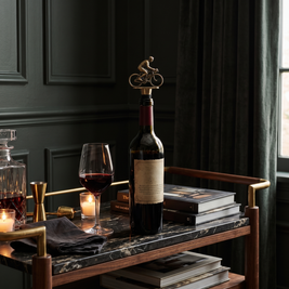 Cyclist wine bottle stopper, Bronze in a dark editorial interior