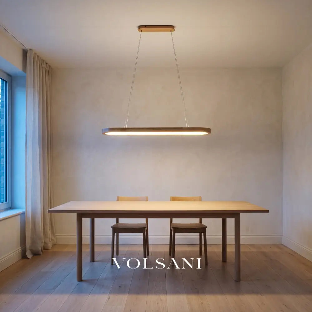 Oval wooden pendant lamp hanging lit above a bare oak dining table at dusk