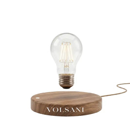 Levitating table lamp with floating bulb on a wood base, white background