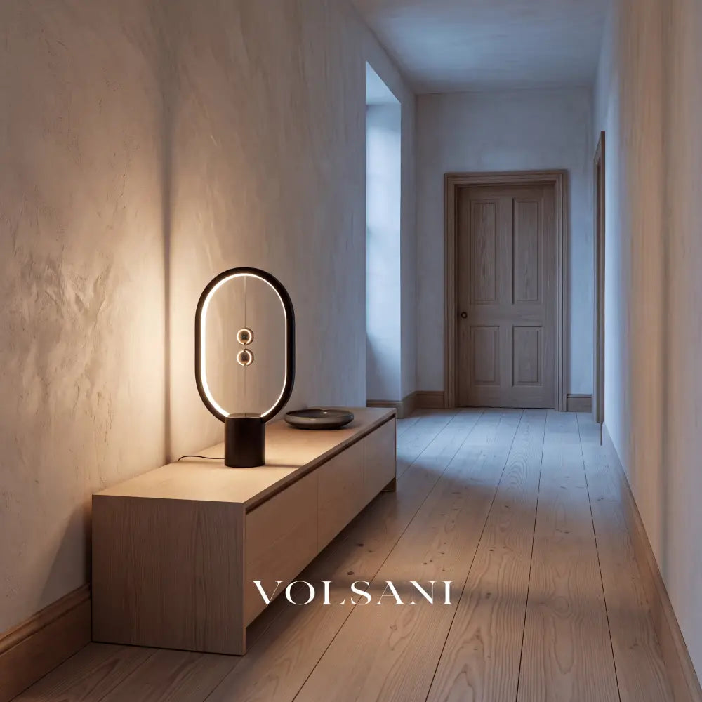 Black magnetic sphere lamp lit on a console in a Japandi hallway at dusk