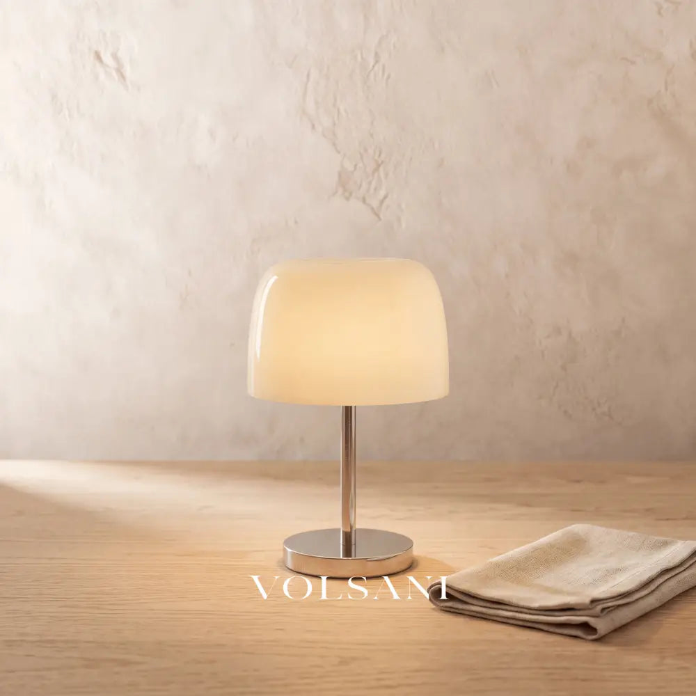 Close-up of the cream Bauhaus glass and chrome lamp on raw oak against a plaster wall