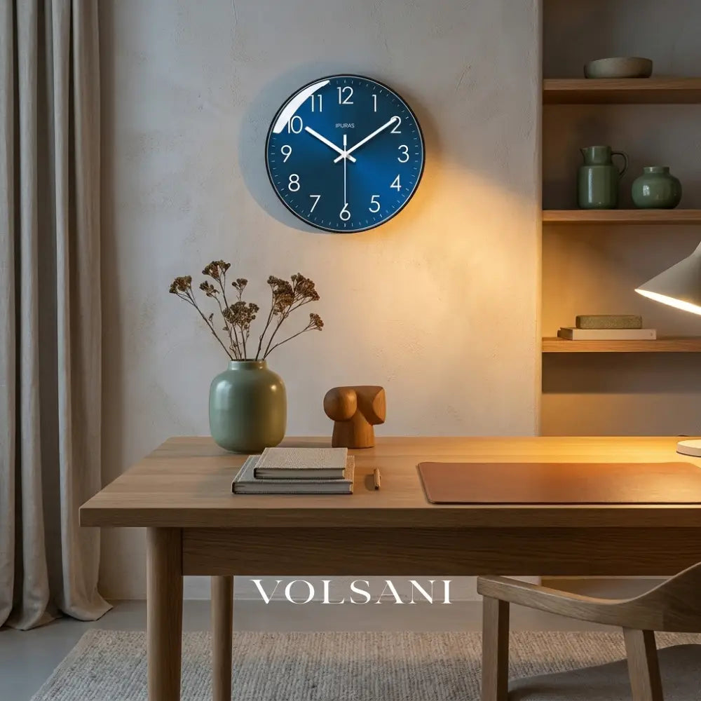 Modern wall clock with blue dial above a desk in a home office
