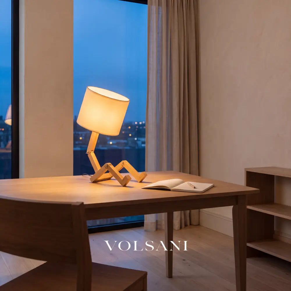 Wood lamp with poseable figure frame lit on a desk in a Japandi home study at dusk