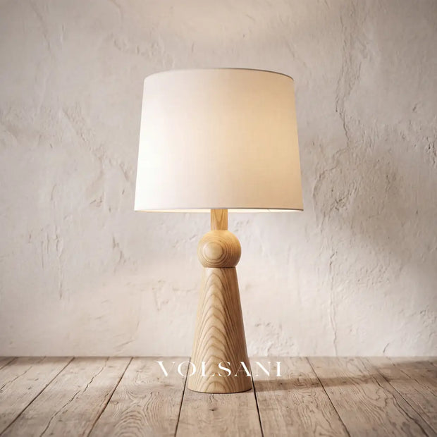 Close-up of the tall Scandinavian wood lamp against a plaster wall