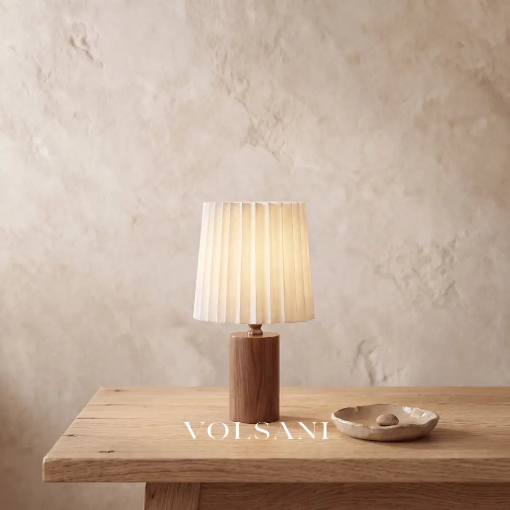 Close-up of the walnut table lamp on raw oak against a plaster wall