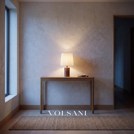 Walnut pleated-linen lamp lit on a console in a Japandi entrance hall at dusk
