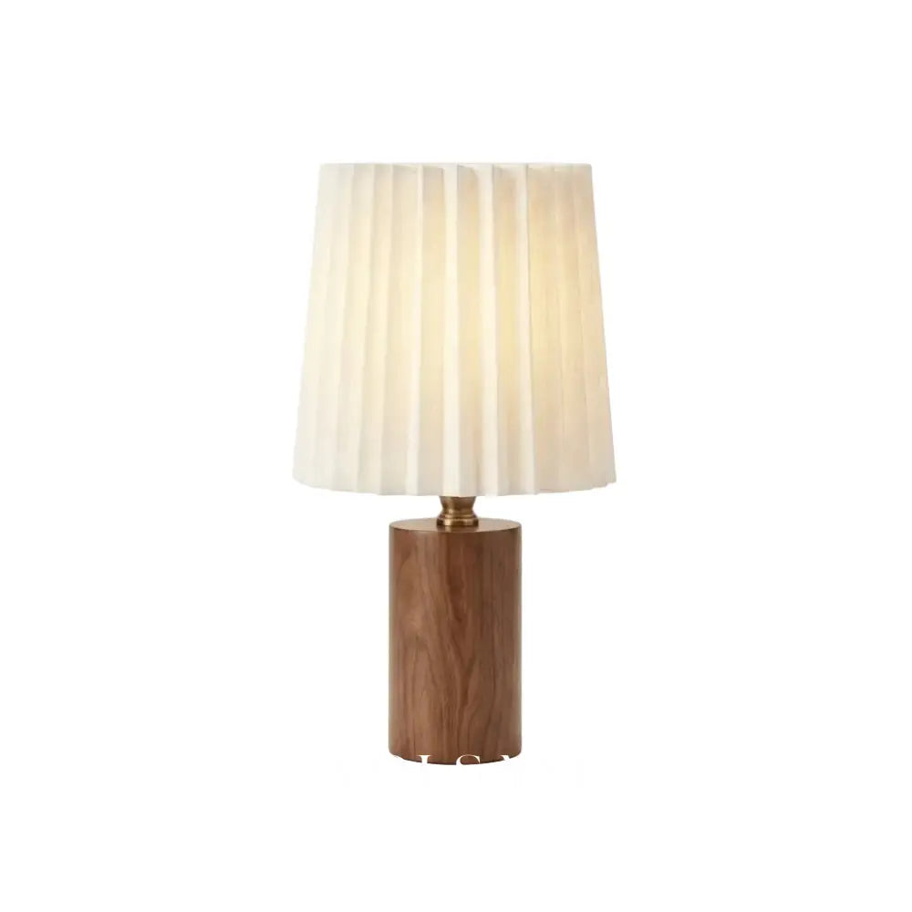 Walnut wood table lamp with pleated linen shade on a white background